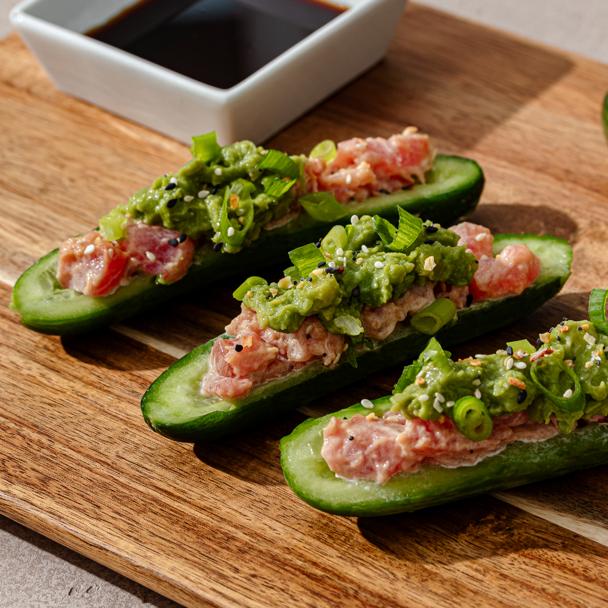 A serving of cucumber sushi boats recipe on a wooden cutting board.