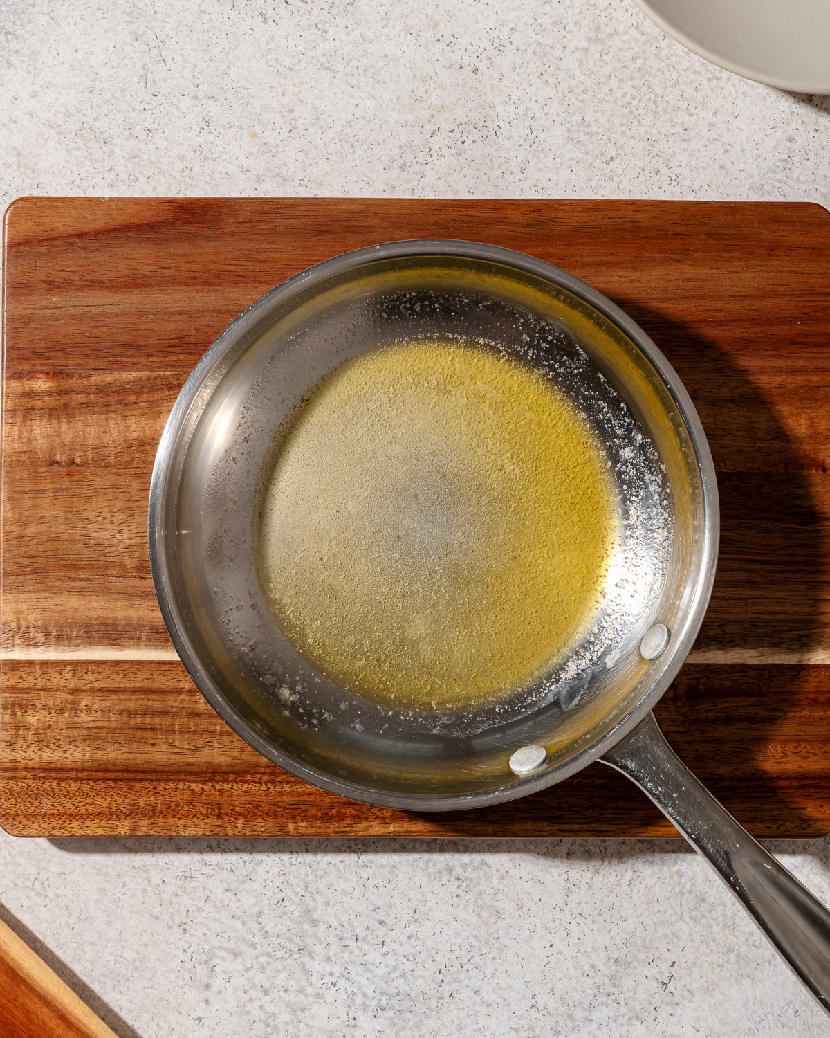 Melted butter in a pan for scrambled eggs without milk.