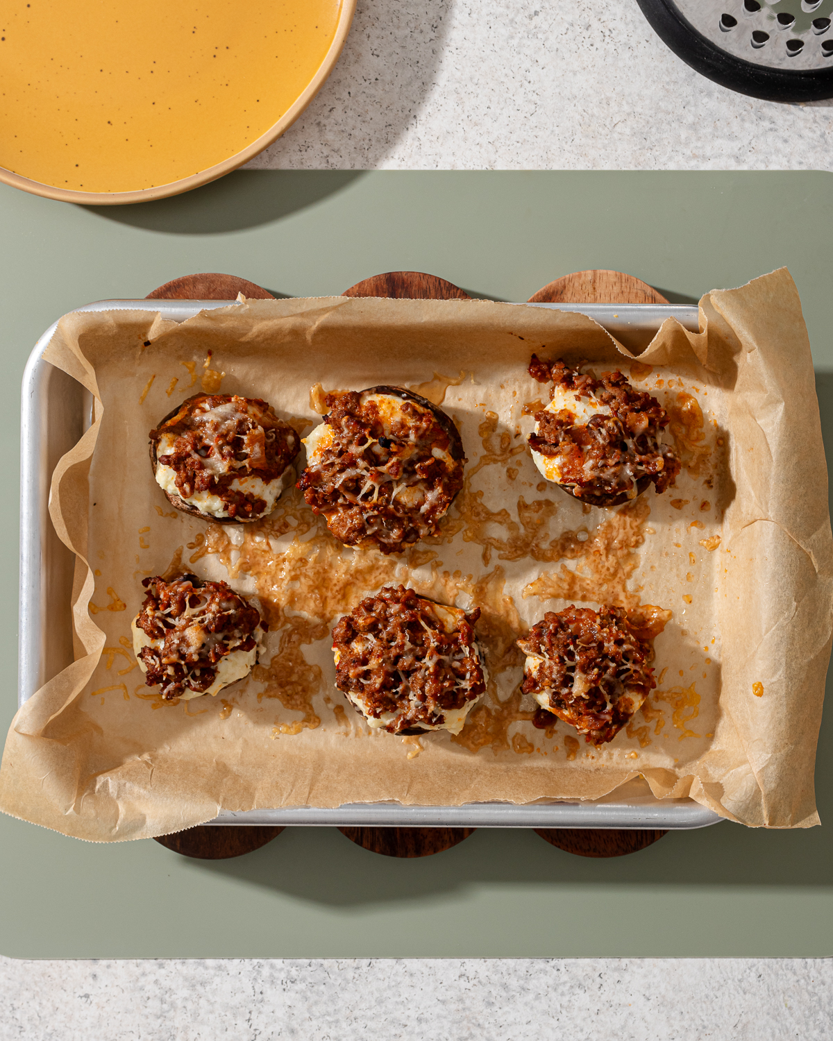 A baking tray with baked stuffed mushrooms with ricotta.