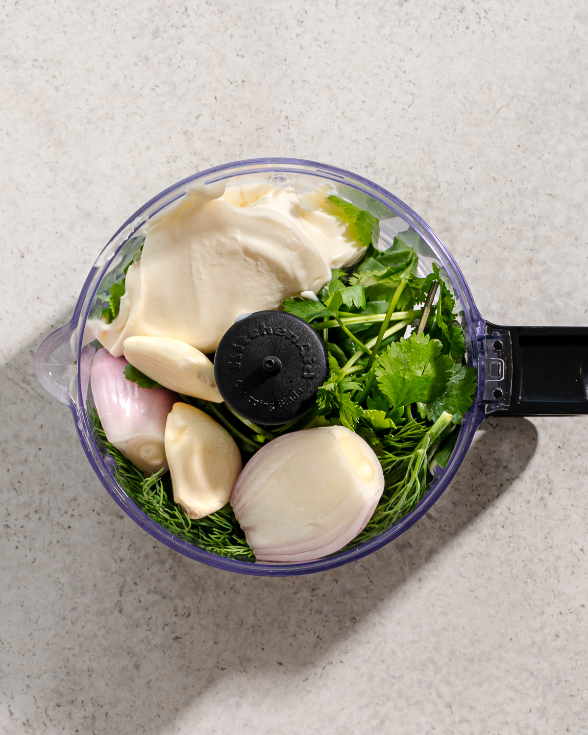 Ingredients for green goddess sauce in a mini food processor.