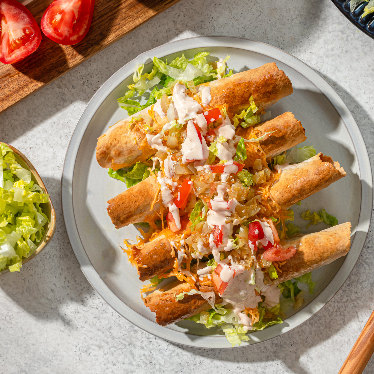 A plate of low carb taquitos with sauce and toppings.