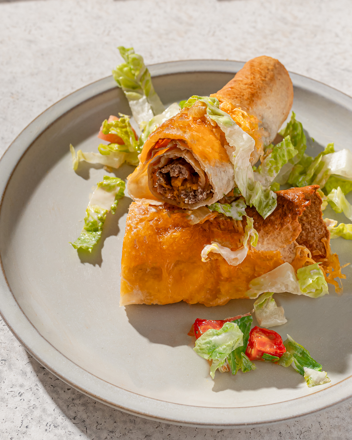 Close-up of low carb taquitos on a gray plate.