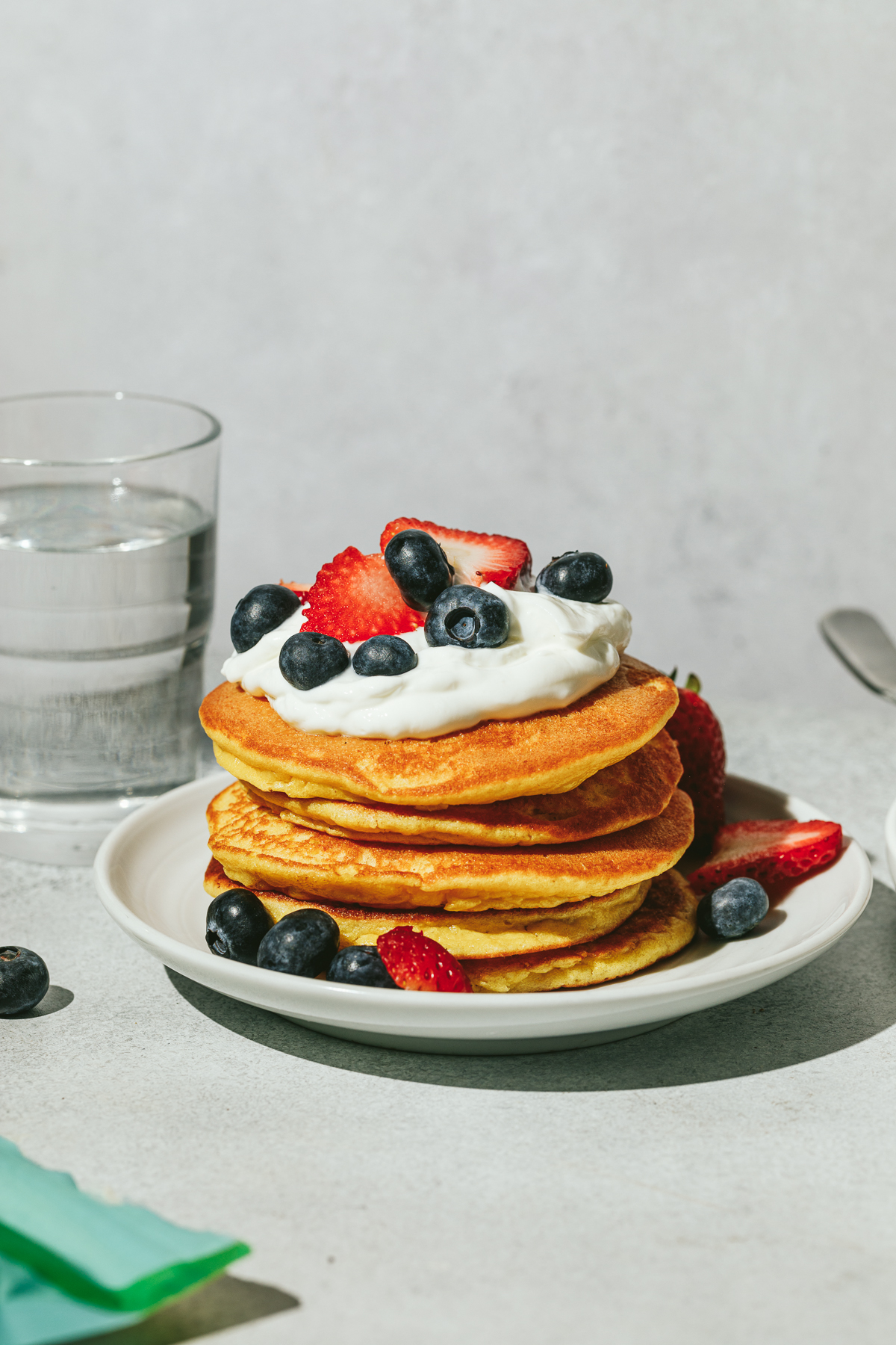 A stack of lupin flour pancakes with whipped cream and toppings.