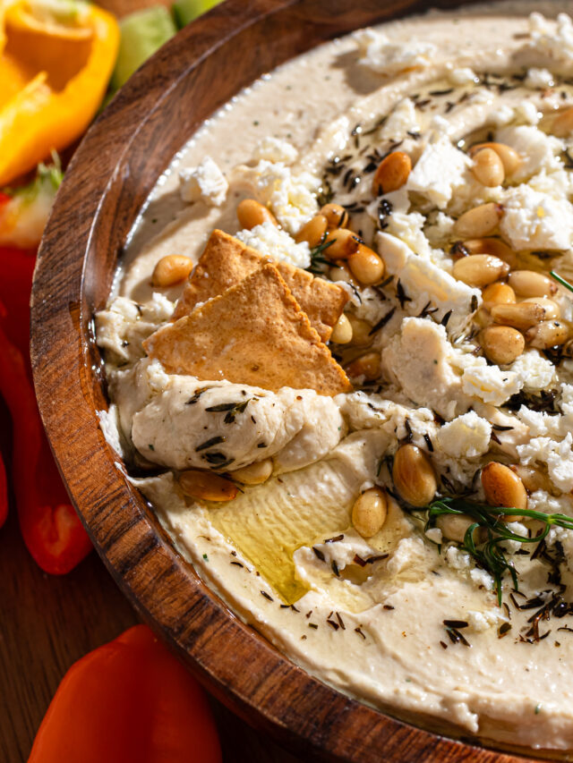 Crackers dipping in a roasted garlic dip recipe.
