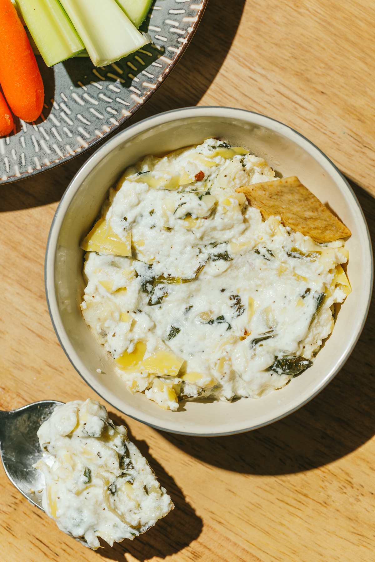 high protein spinach artichoke dip in a bowl