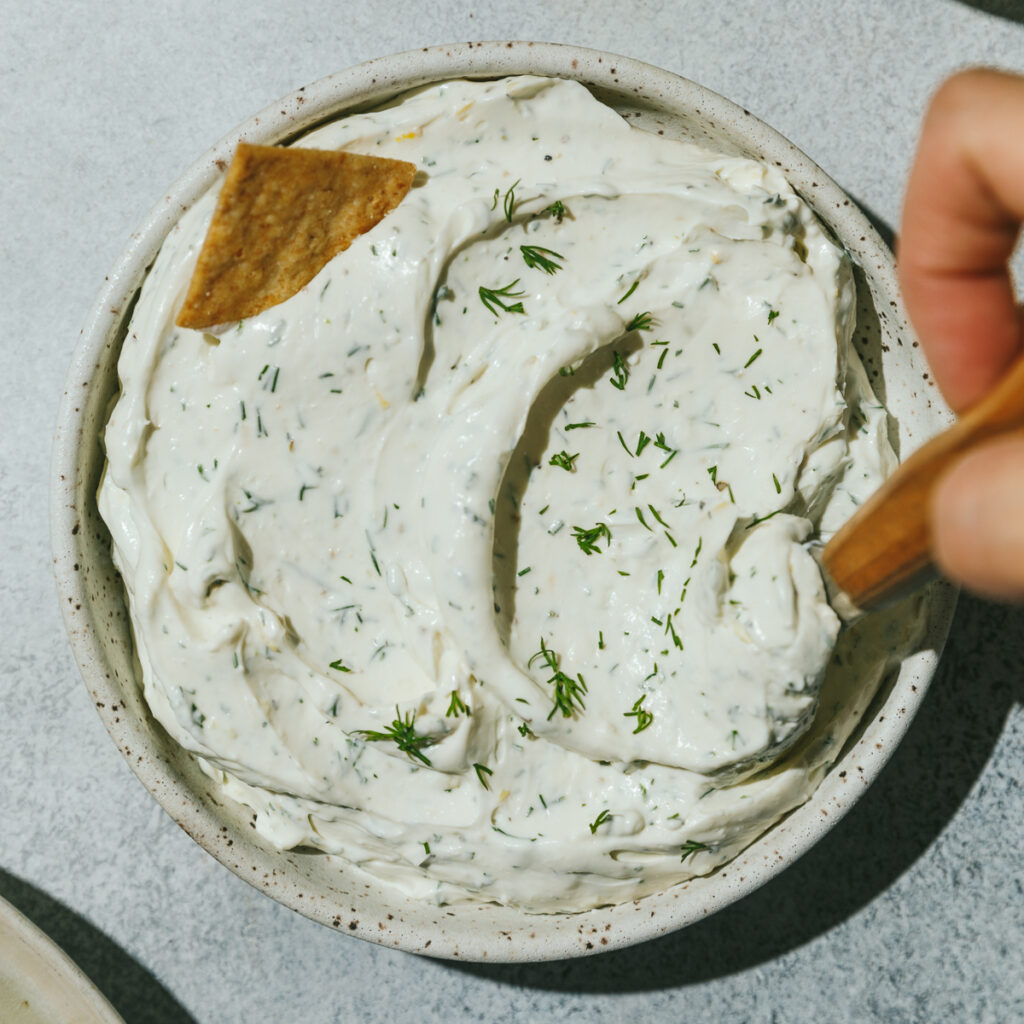 Low-carb dill cream cheese spread in a bowl with a cracker.