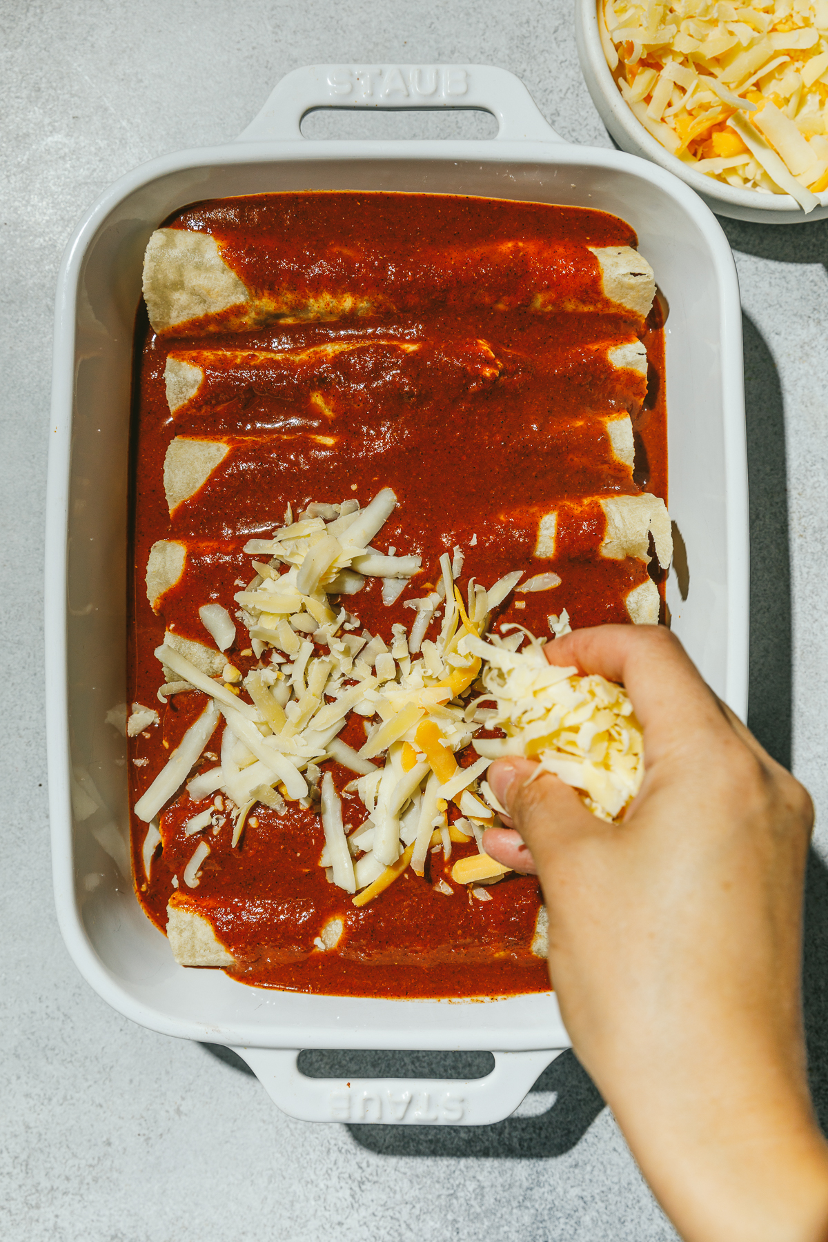putting cheese on high protein chicken enchiladas